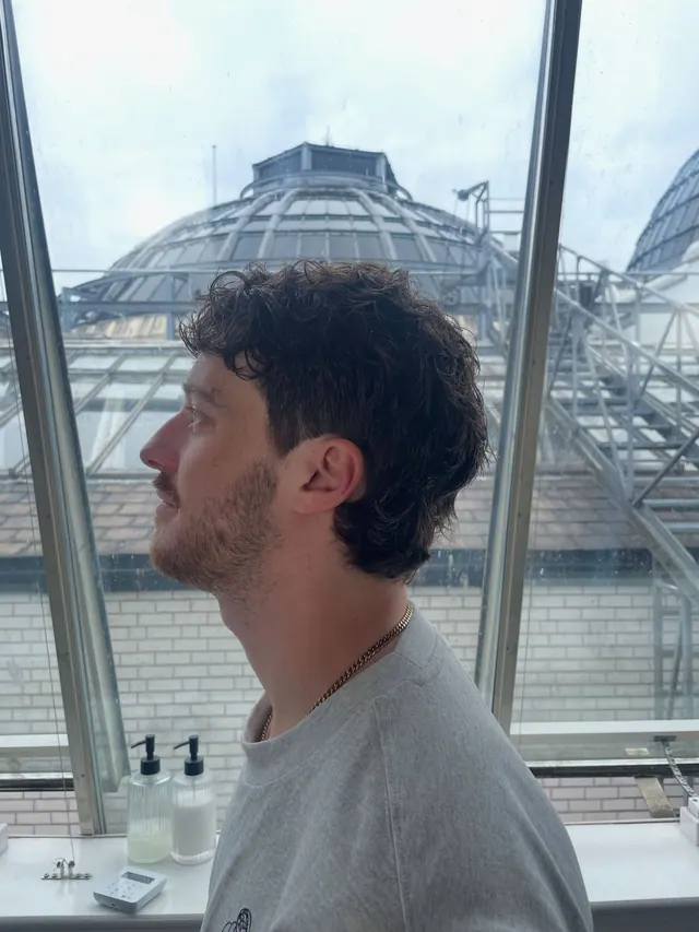 Curly textured cut, with the Royal Exchange dome behind